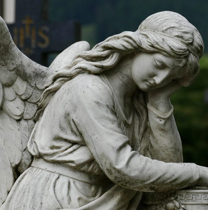 Trauernde Engelsfigur aus Stein auf einem Friedhof